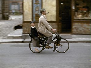 image of man riding bicycle with kid in back